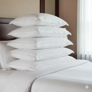A neat stack of several fluffy, white best goose down pillow luxury hotel style.